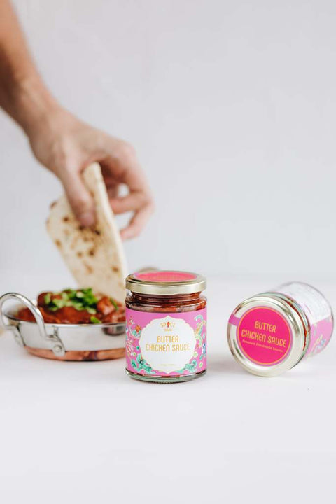 Dipping Garlic Naan in creamy Butter Chicken.